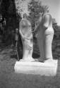 Henry Moore holding his camera while siting <i>Three Standing Figures</i> 1947-48 (Darley Dale …